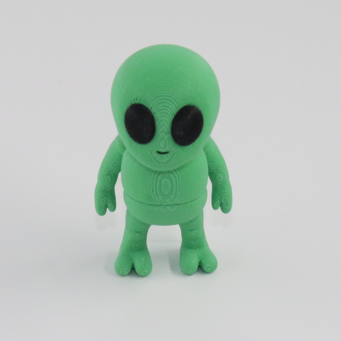Green alien toy on a white background