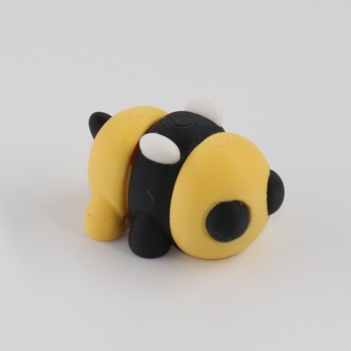 Small black and yellow bee-shaped object on a white background