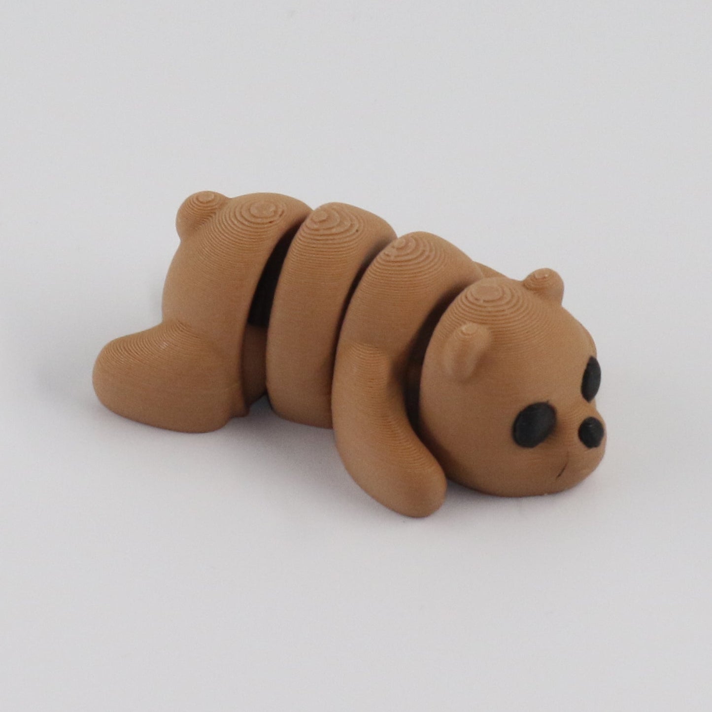 Small brown bear figurine on a white background