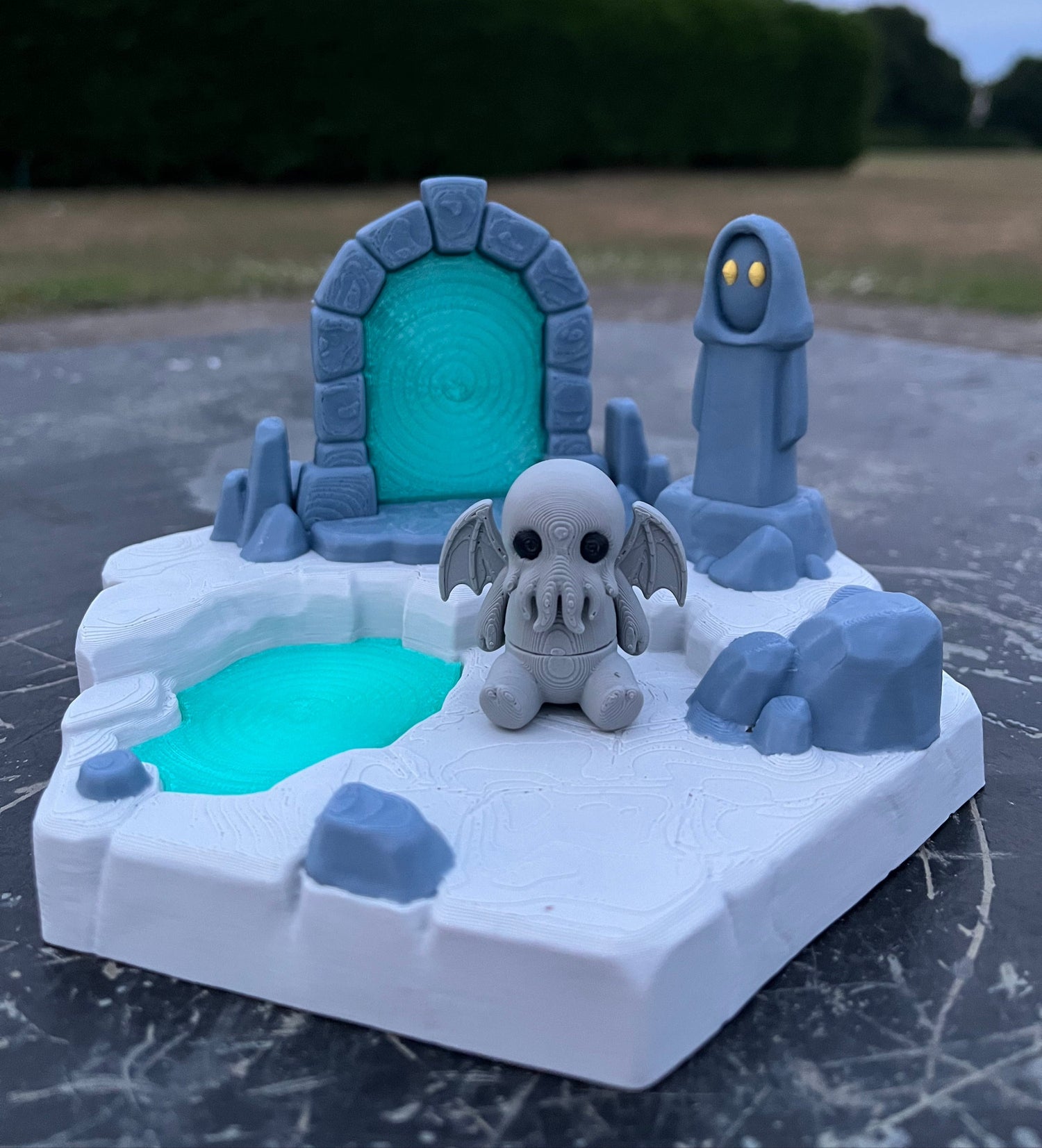 Toy figure of a character with a blue and gray color scheme on a dark surface.