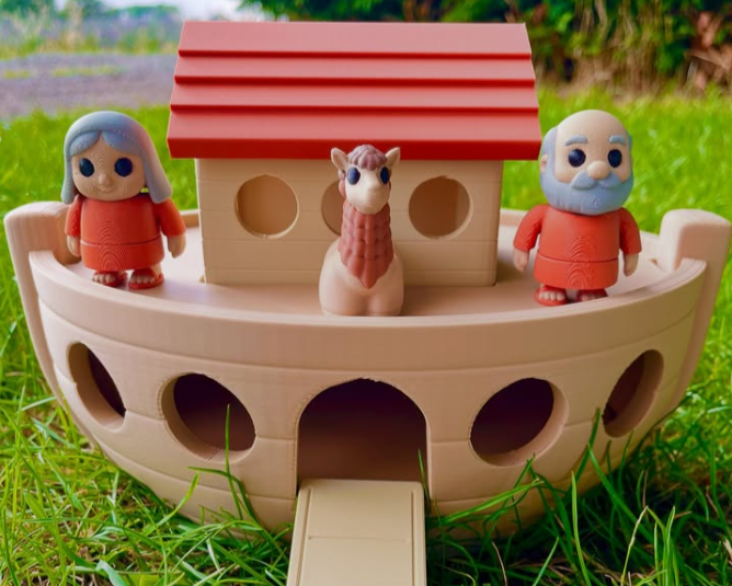Toy Noah's Ark with figurines on a grassy background