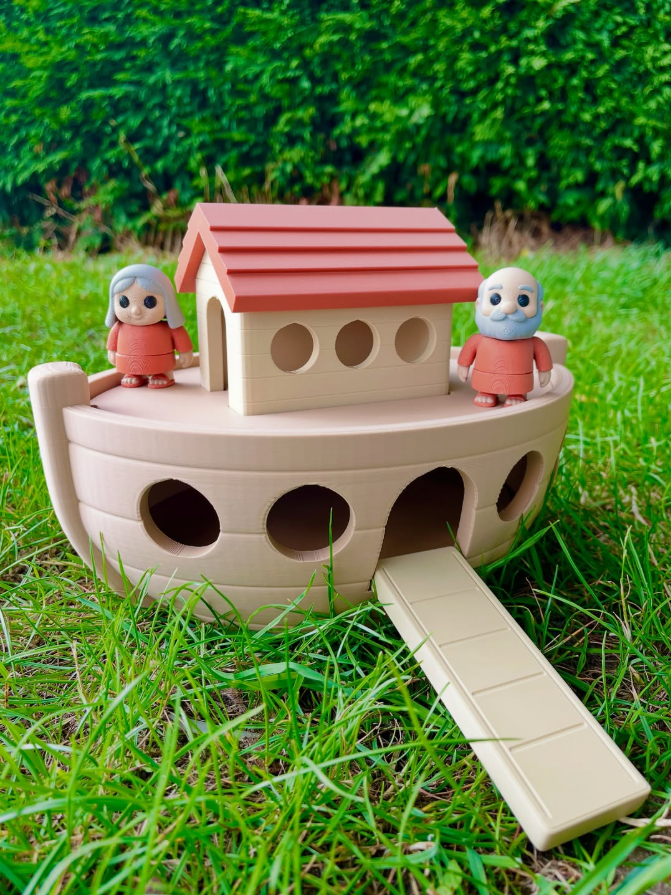 Toy Noah's Ark with two figures on a grassy background