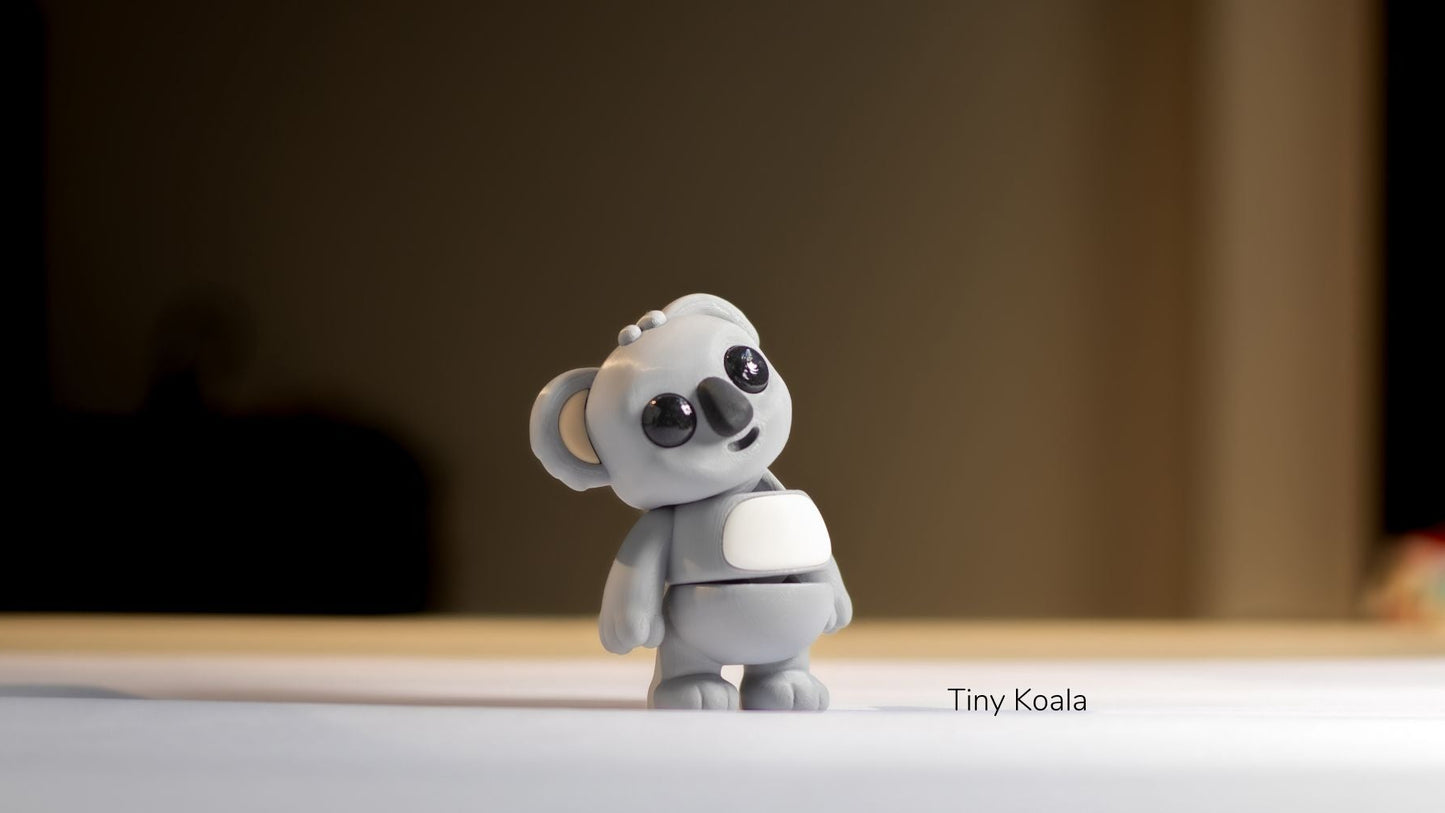 Small gray koala figurine on a reflective surface with a blurred background
