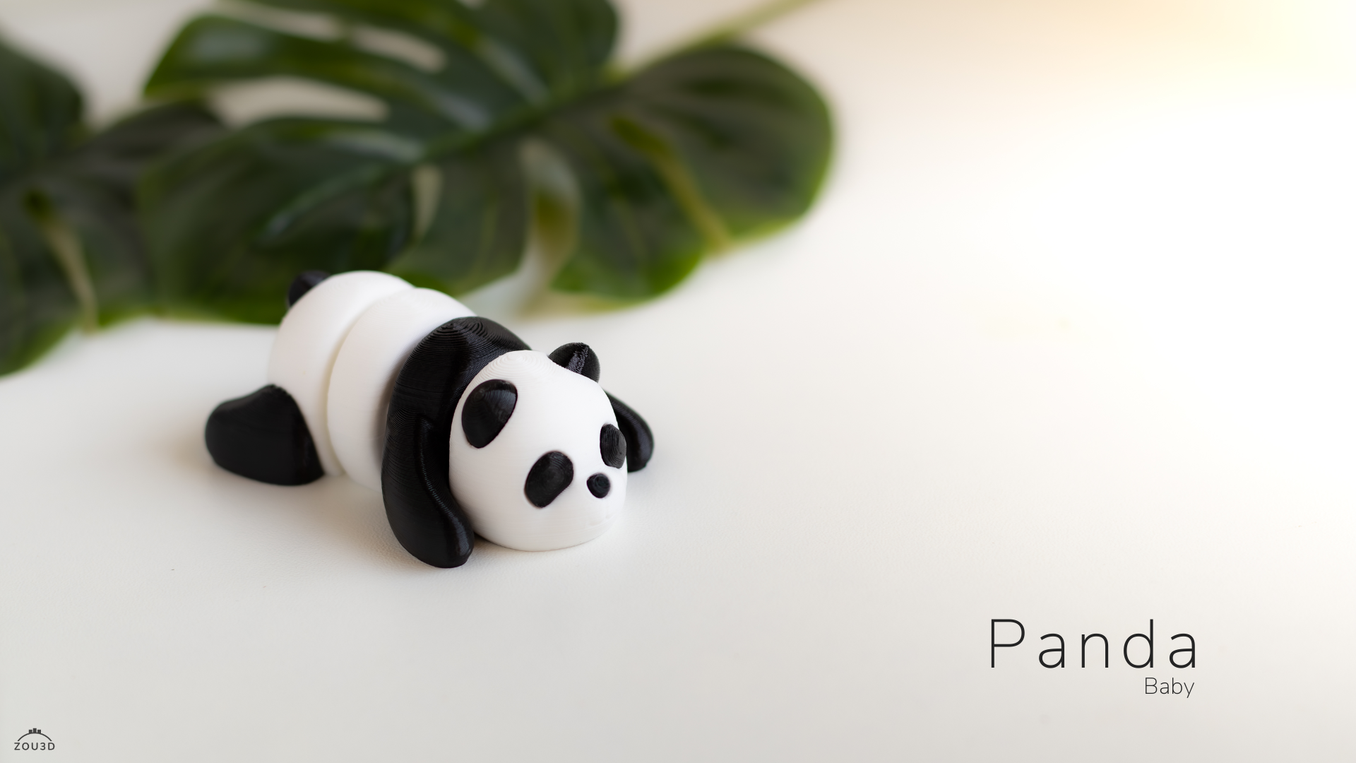 Panda-shaped object on a white surface with green leaves in the background
