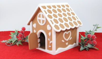 Gingerbread house model on a red surface with decorative elements