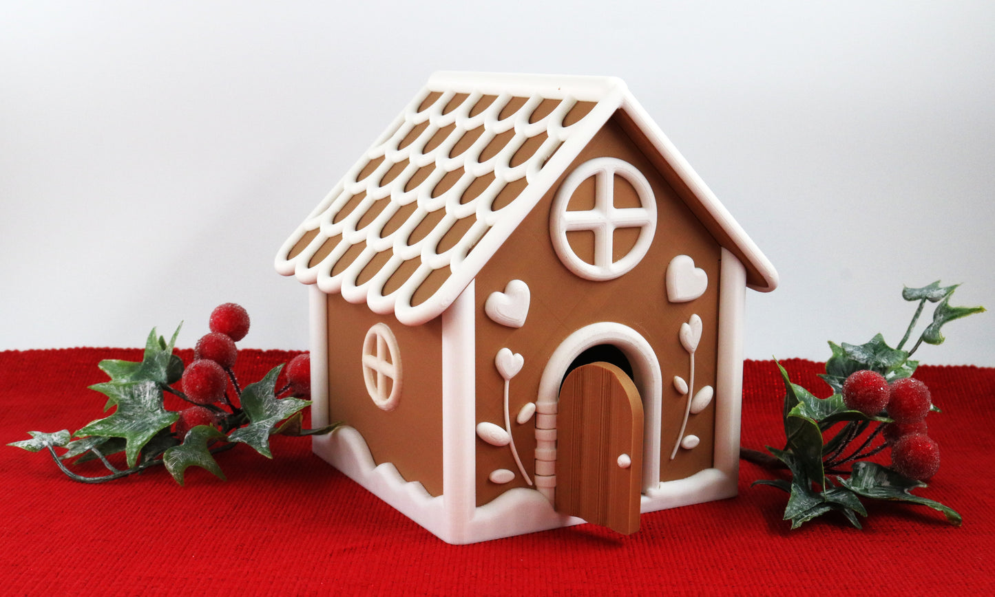 Decorative gingerbread house with a white roof on a red surface with greenery.