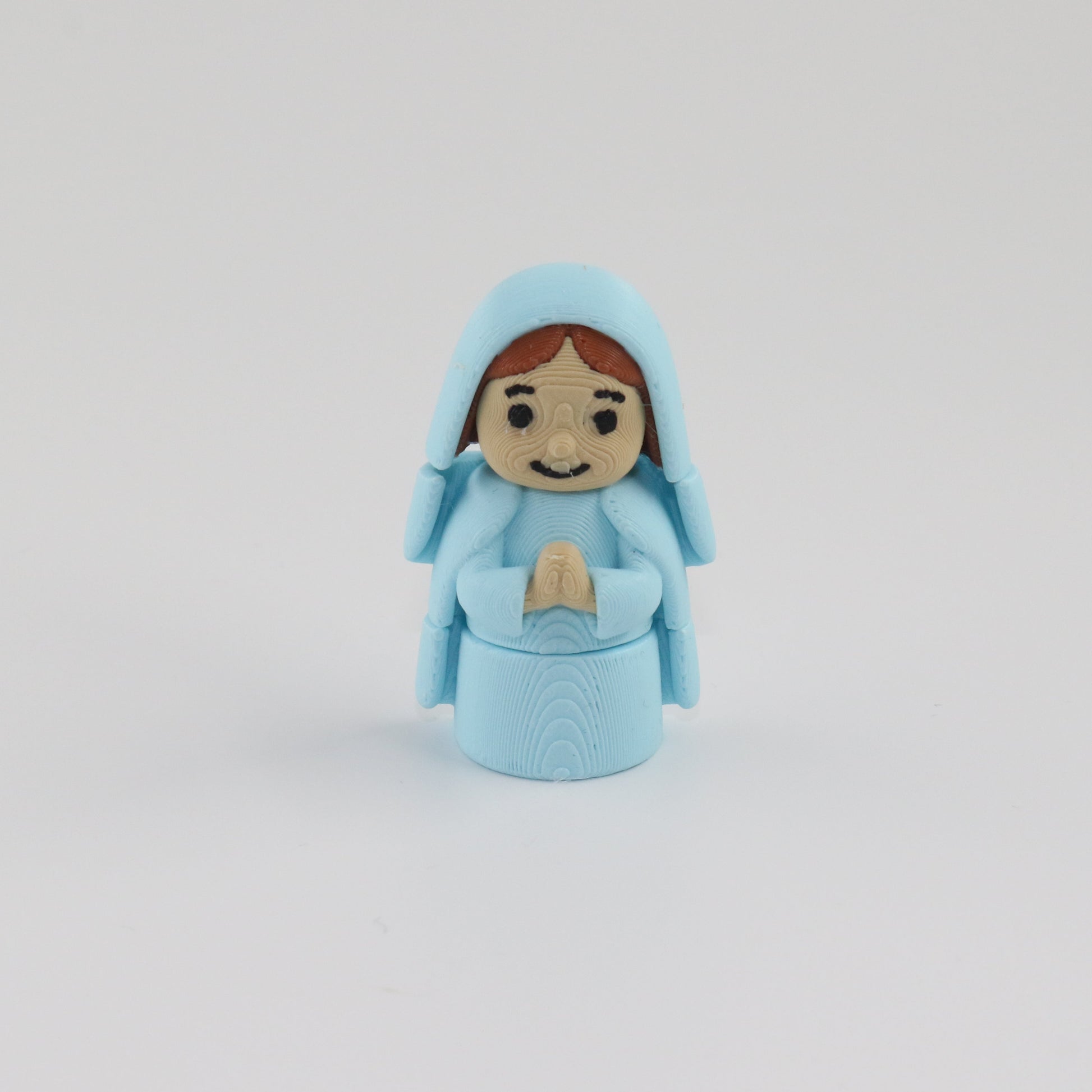 Small figurine of a person in a blue outfit on a white background