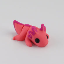 Small pink axolotl figurine on a light white background