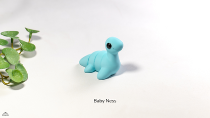 Blue toy seal on a white background with 'Baby Ness' text