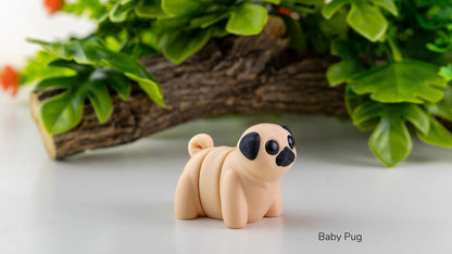 Baby pug figurine on a white surface with greenery in the background