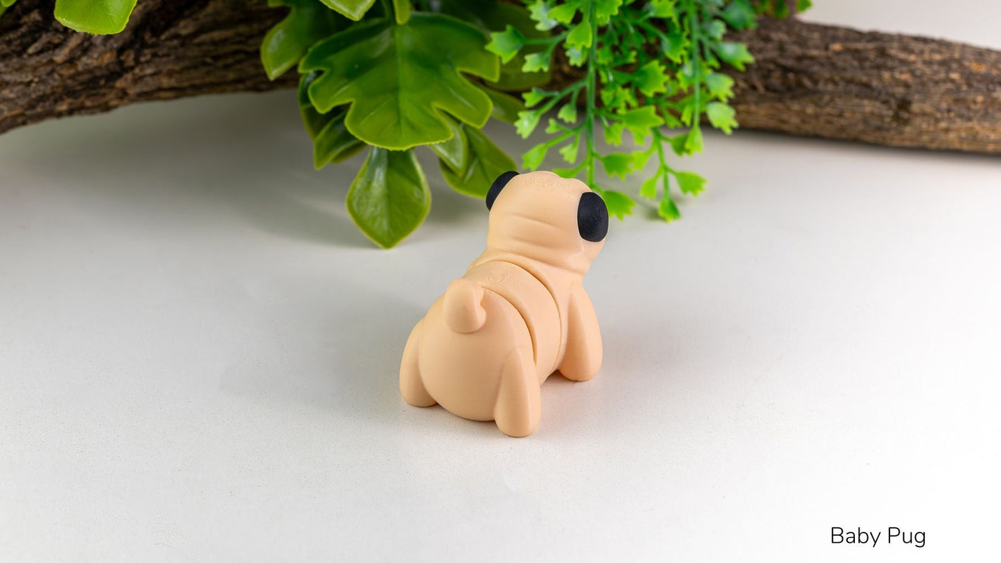 Small figurine of a baby pug sitting on a light surface with green leaves in the background