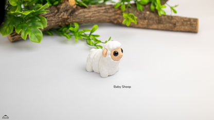Small white sheep figurine on a light surface with greenery in the background