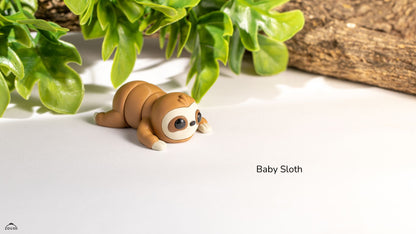 Toy sloth on a white surface with green leaves in the background