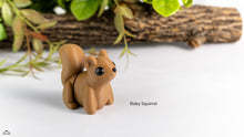 Small brown squirrel figurine on a white surface with greenery in the background
