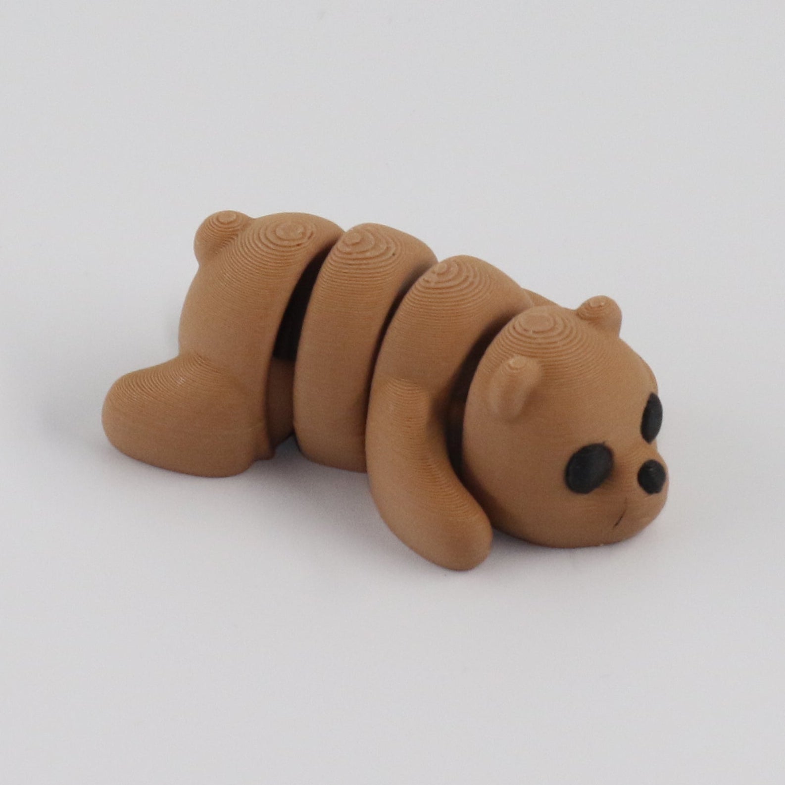 Small brown bear figurine on a white background