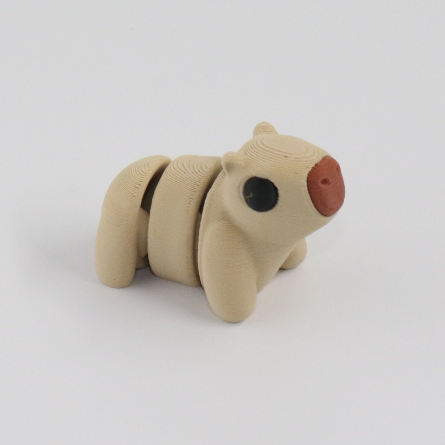 Small beige capybara on a white background