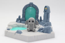 A light grey articulated cthulhu and a portal playset with a transparent blue portal and pool of water, and a grey statue spirit