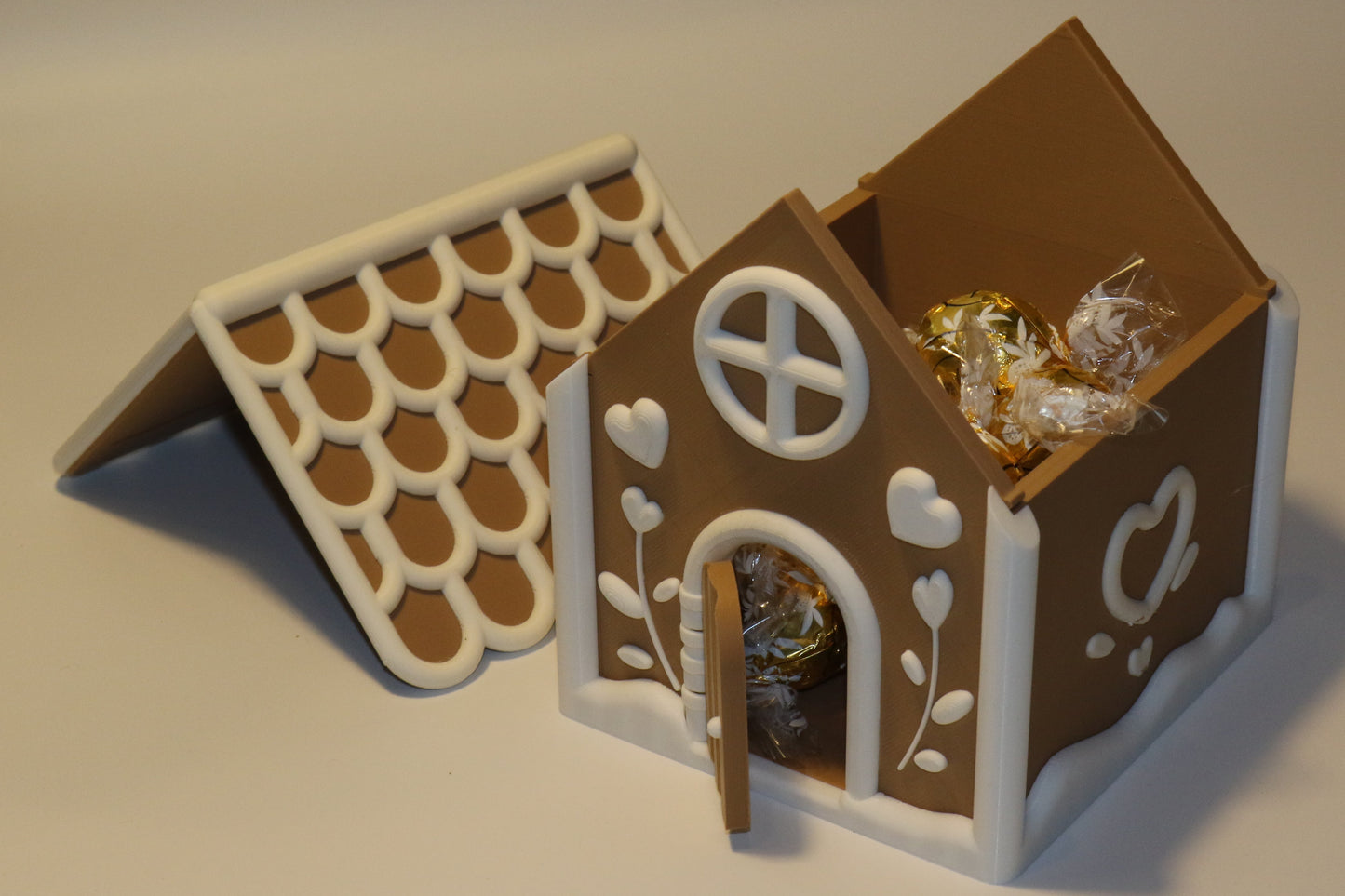 Gingerbread house model with decorative elements, with sweets inside, on a white background