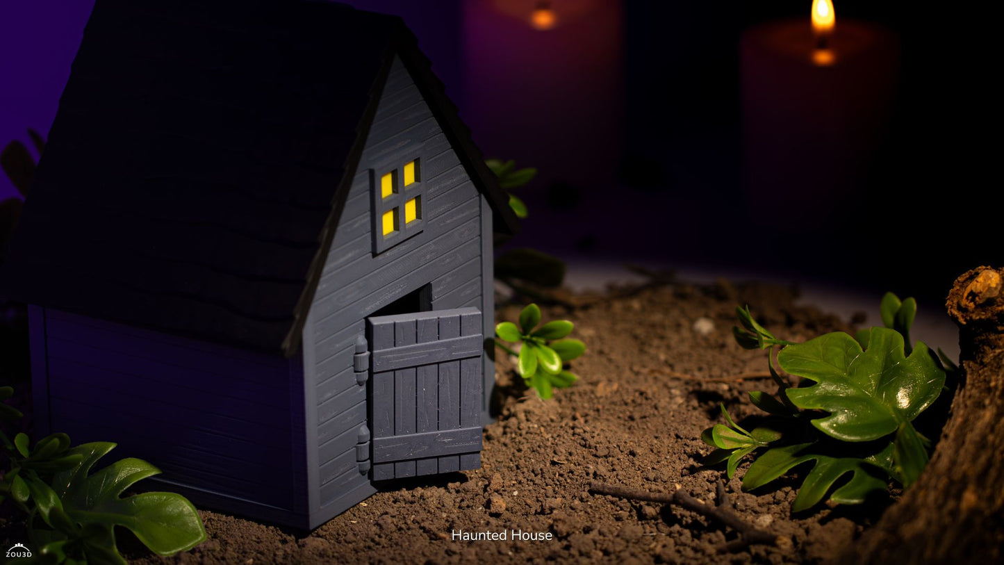 Small model of a haunted house with glowing windows on a dark background