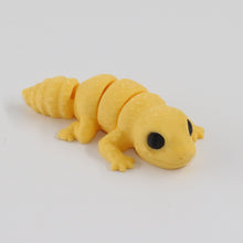 Yellow toy lizard on a light white background