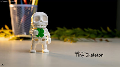 Small skeleton figurine with a green clover, labeled 'Lucky clover Tiny Skeleton', on a blurred background.
