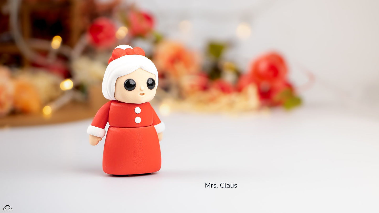 Fimo figure of Mrs. Claus on a white surface with blurred Christmas decorations in the background