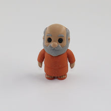 Small figurine of an elderly man in a brown outfit on a white background