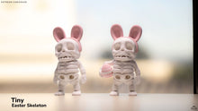 Two skeleton figures with bunny ears on a blurred background