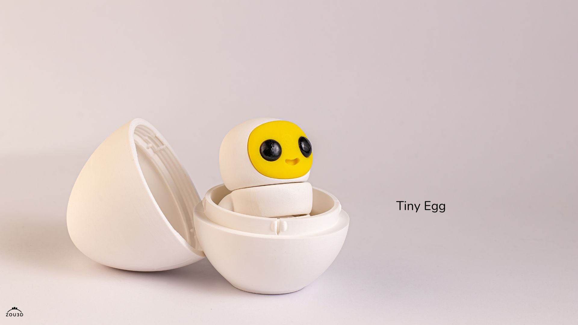 Small characterwith a yellow face and black eyes in an open white egg-shaped case on a light gray background.