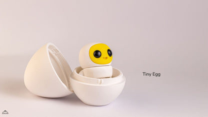 Small characterwith a yellow face and black eyes in an open white egg-shaped case on a light gray background.