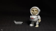 Tiny skeleton astronaut figurine on a dark background