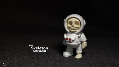 Tiny skeleton astronaut figurine on a dark background