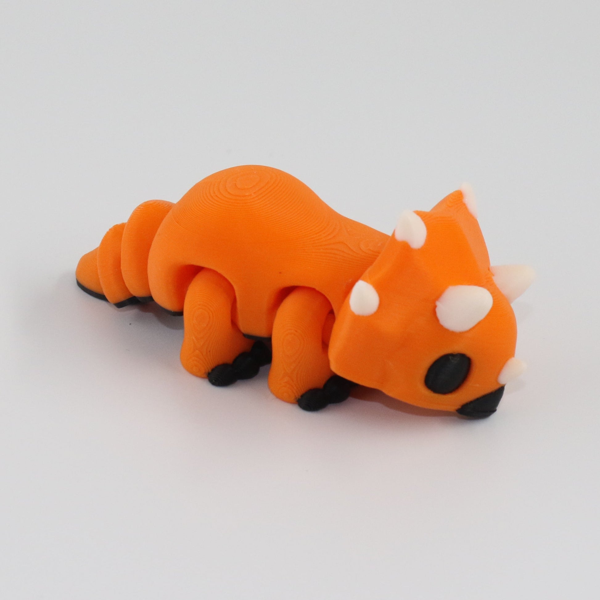Orange toy dinosaur on a gray background