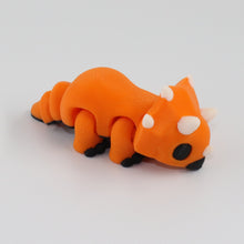 Orange toy dinosaur on a gray background