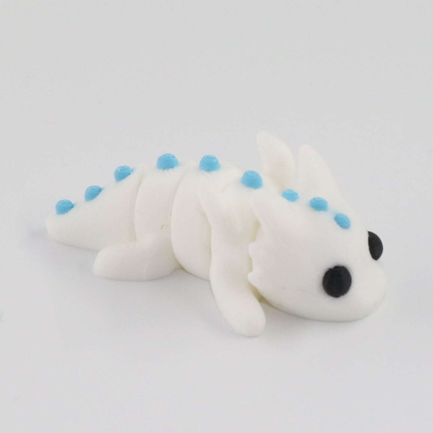 Small white toy with blue spots on a light gray background