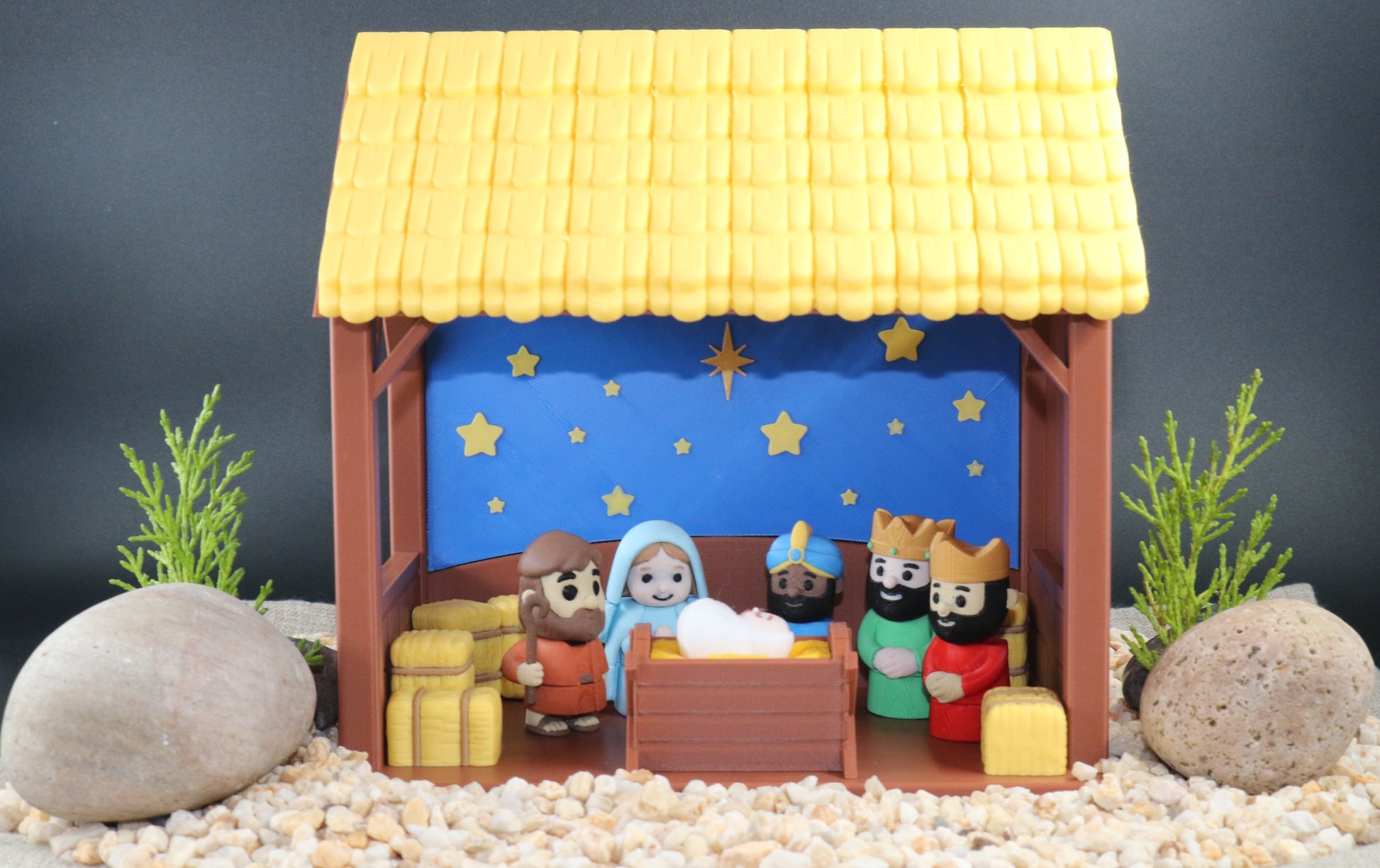 Nativity scene model with stable and figures on a dark background