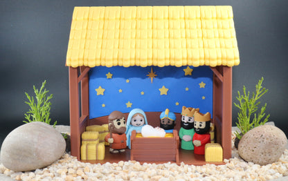 Nativity scene model with stable and figures on a dark background